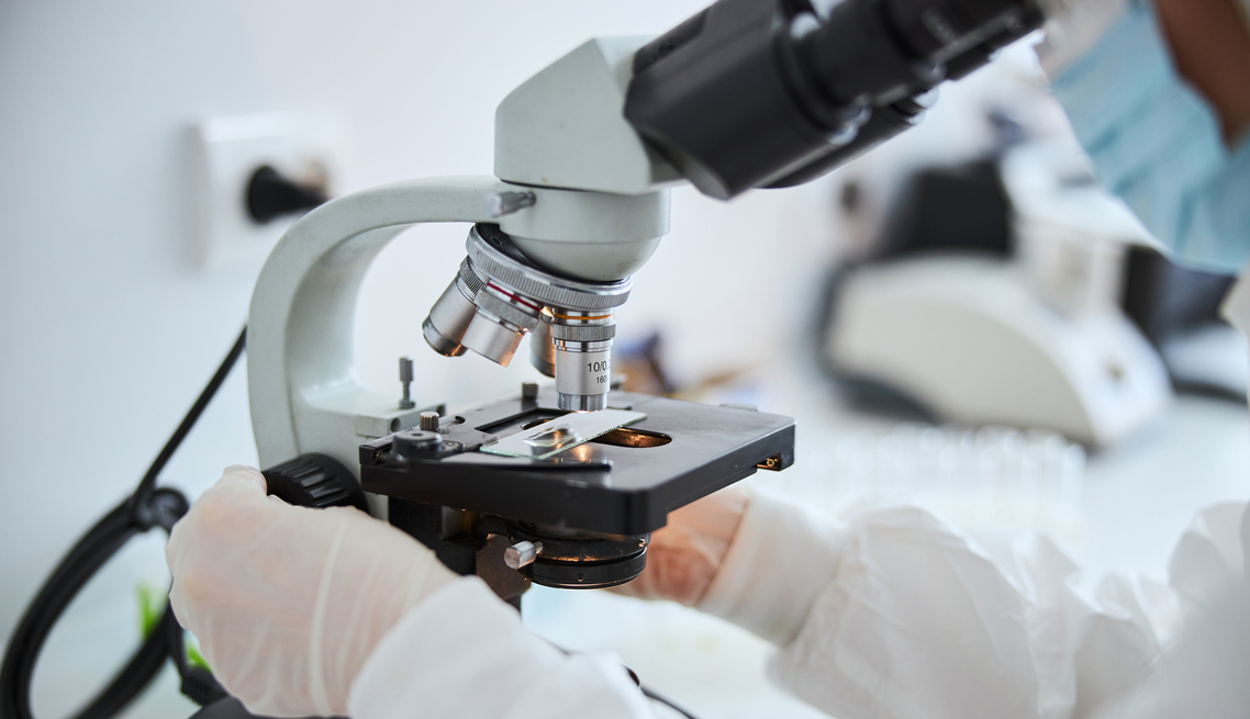 Lab technician examining cells under the microscope